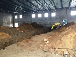 A trench is dug to replace the main sanitary pipe underneath the gymnasium.