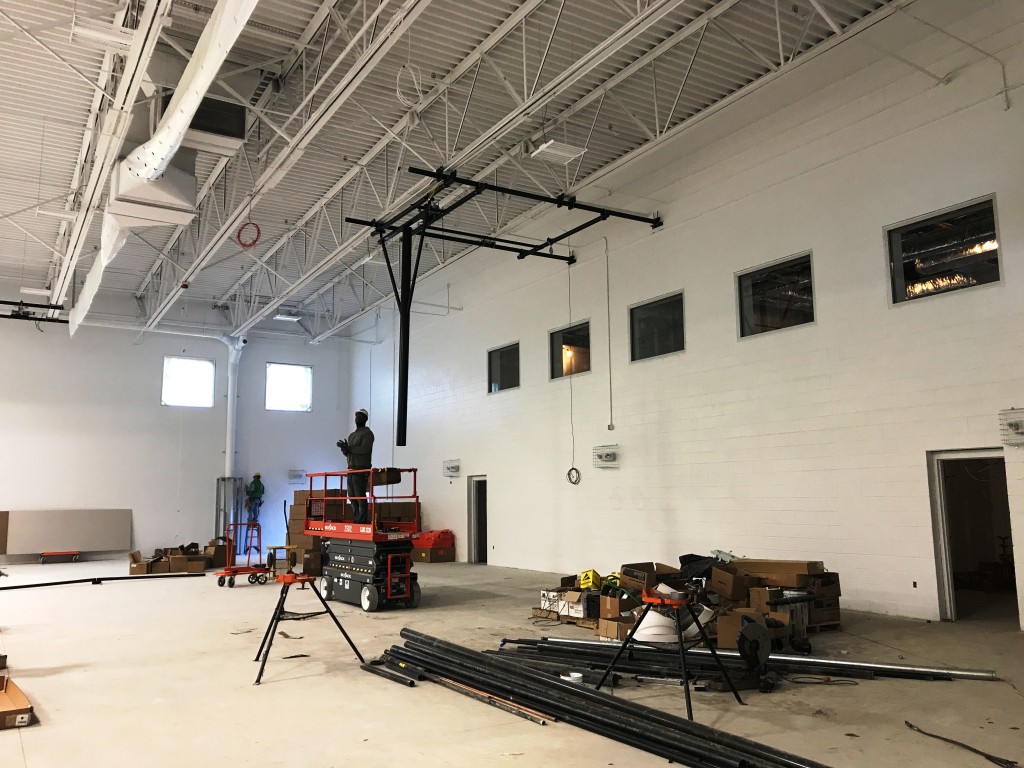 In the gymnasium, the mechanical equipment is being installed including the basketball hoops and divider curtain. Final paint, emergency lights and duct work are all complete.